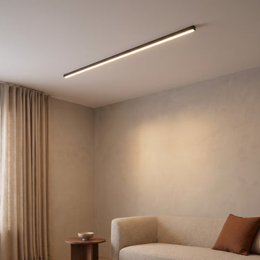 Linear Flush Mount Ceiling Light | Slim LED Bar in Black or White – switched on in a room
