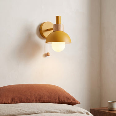Pastel Globe Wall Sconce | Wood Accent Light with Pull Chain – switched on in a room
