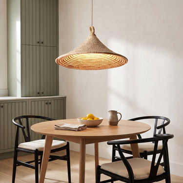 Spiral Rattan Cone Pendant Light | Handwoven Bamboo Hanging Lamp – switched on in a room
