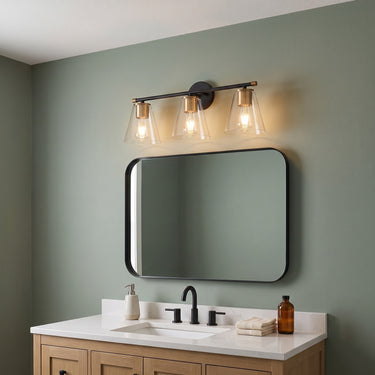 Three-Light Clear Glass Vanity Light | Black and Brass Bath Fixture – switched on in a room